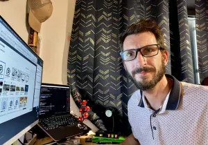 Régis Peter / PeterAtWeb devant son bureau.